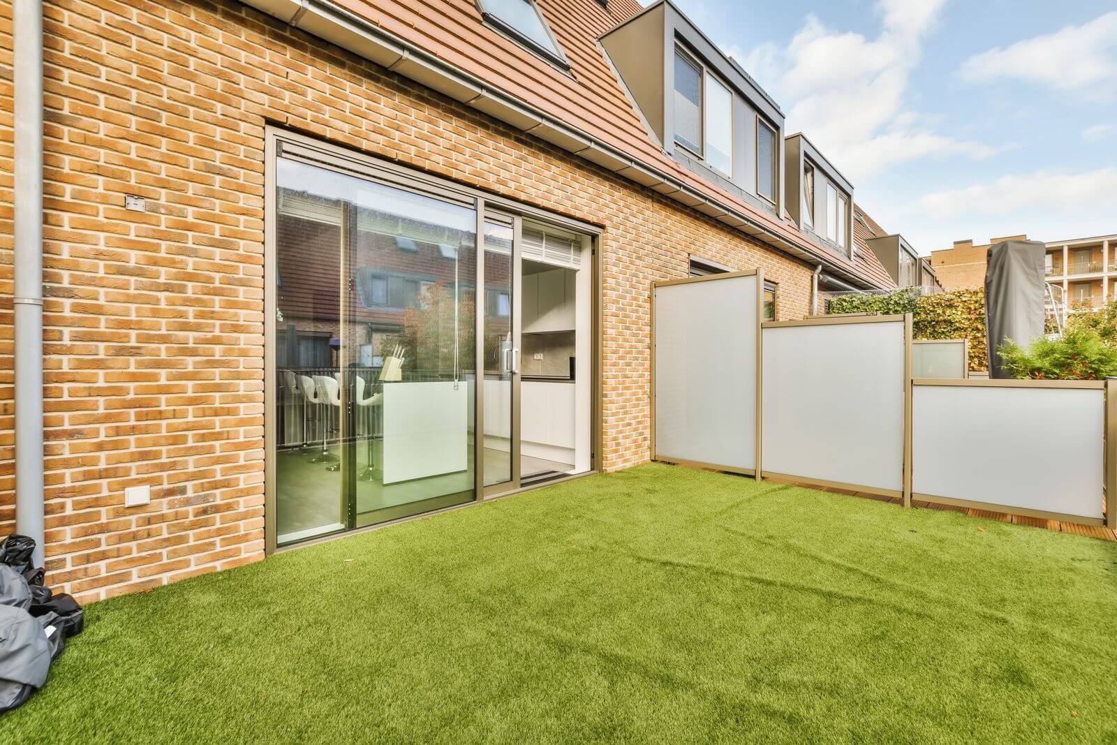 a-backyard-with-a-lawn-and-a-sliding-glass-door